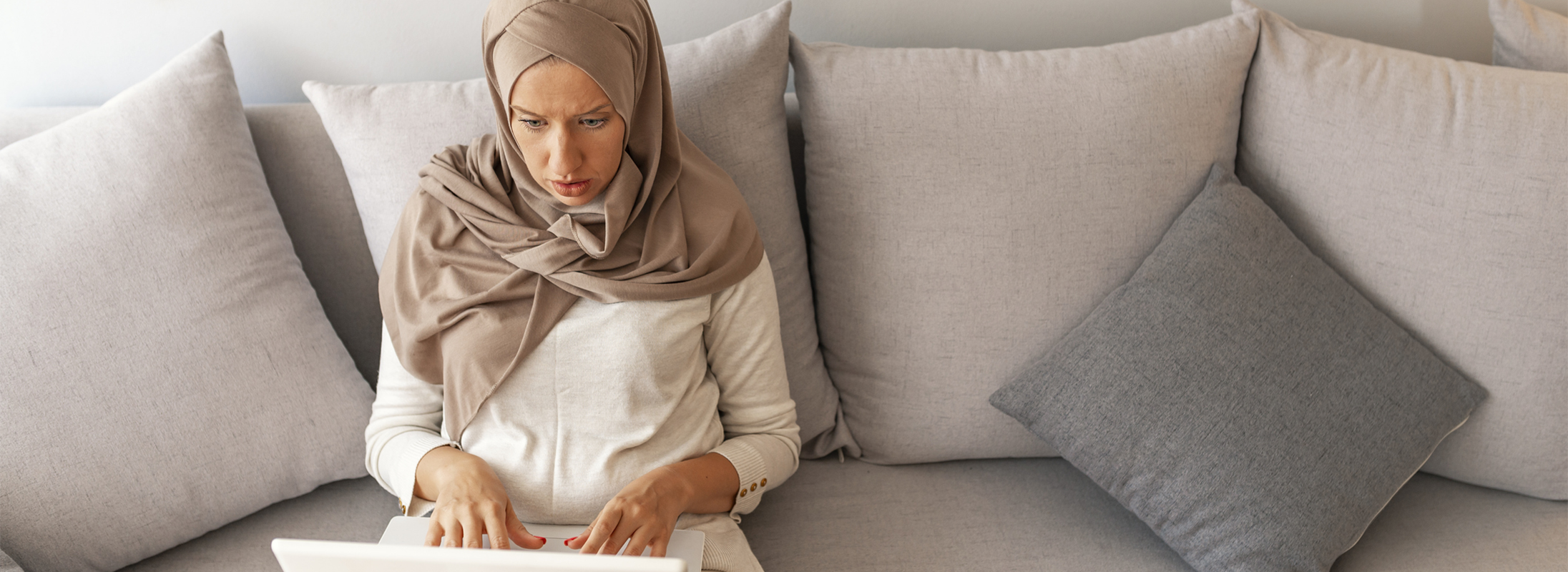 Woman sitting on sofa looking at laptop 