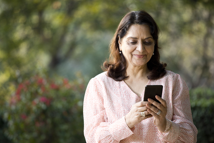 Older woman smiles at phone