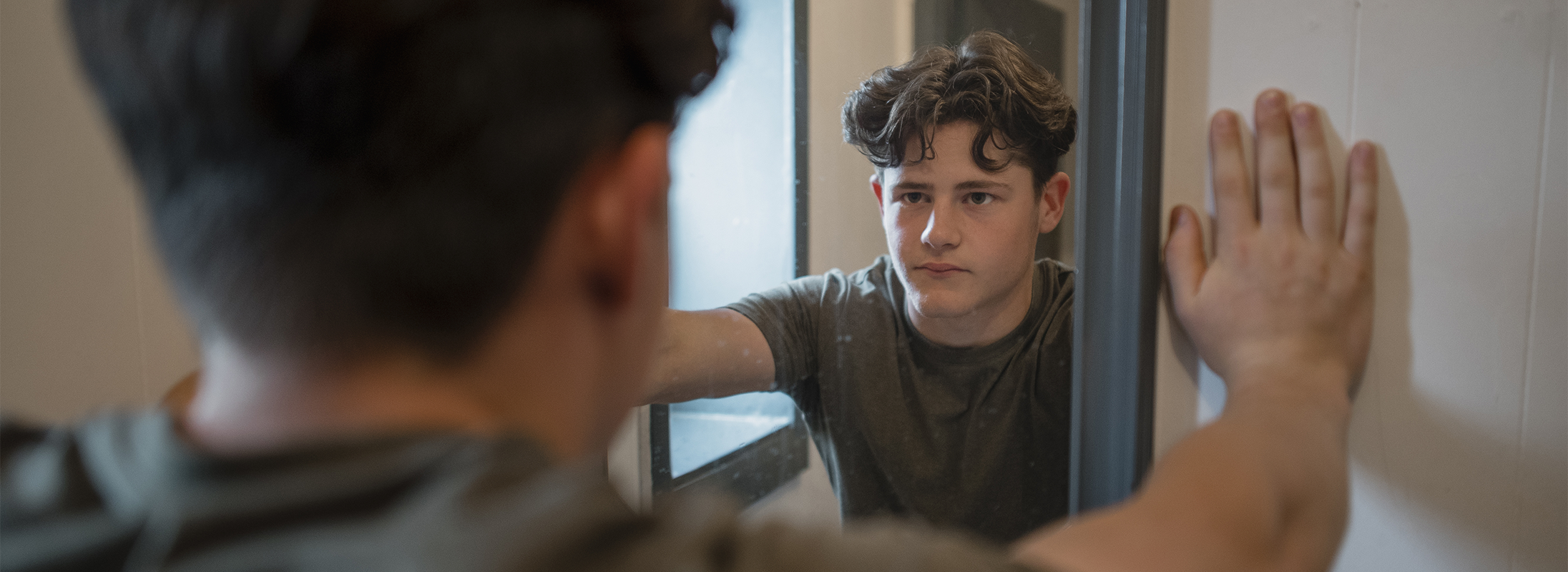 Teen looking in mirror